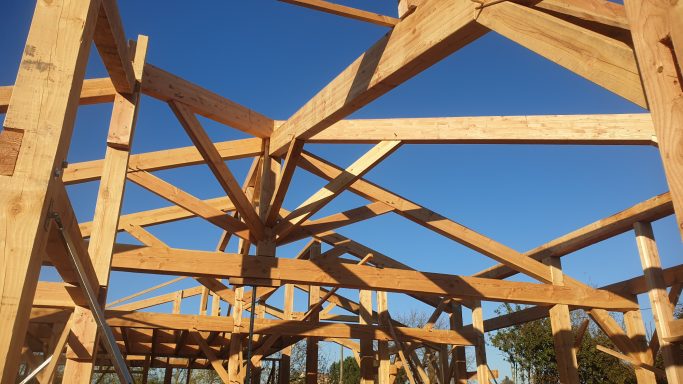 Structure en bois en construction sous un ciel bleu.