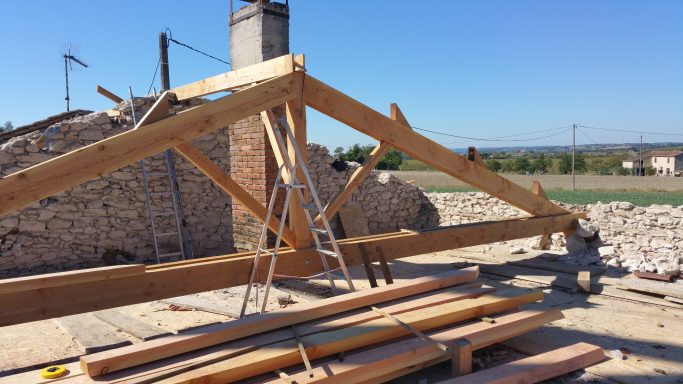 Structure en bois en cours de construction avec des matériaux sur un site de chantier.